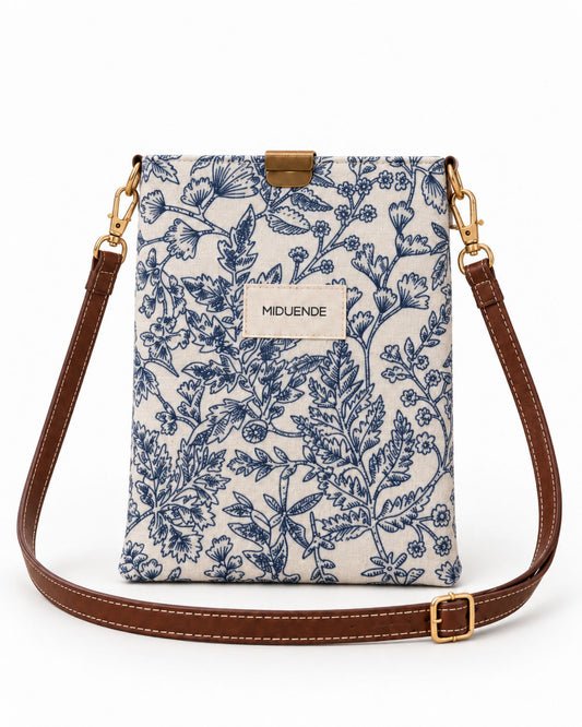 Bolso midi en tela estampada Jara azul con correa de cuero marrón y cierre magnético.