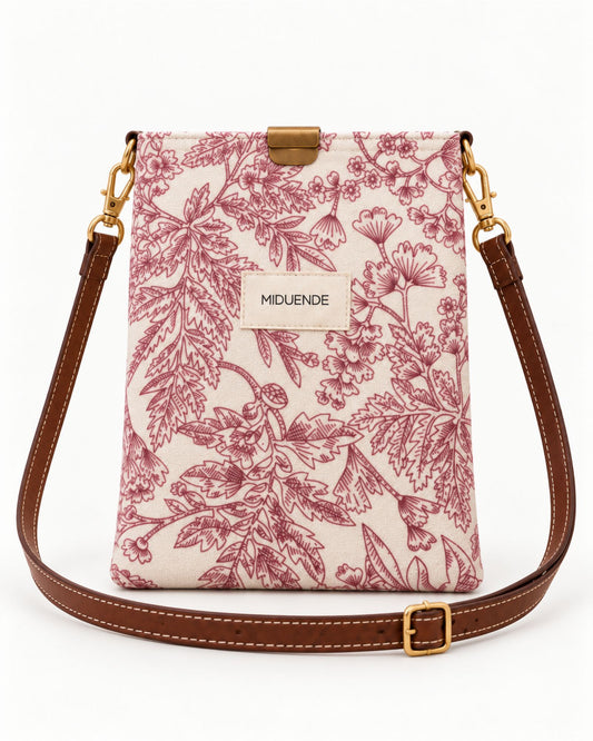 Bolso midi en estampado Jara rosa con correa de cuero marrón y cierre magnético.