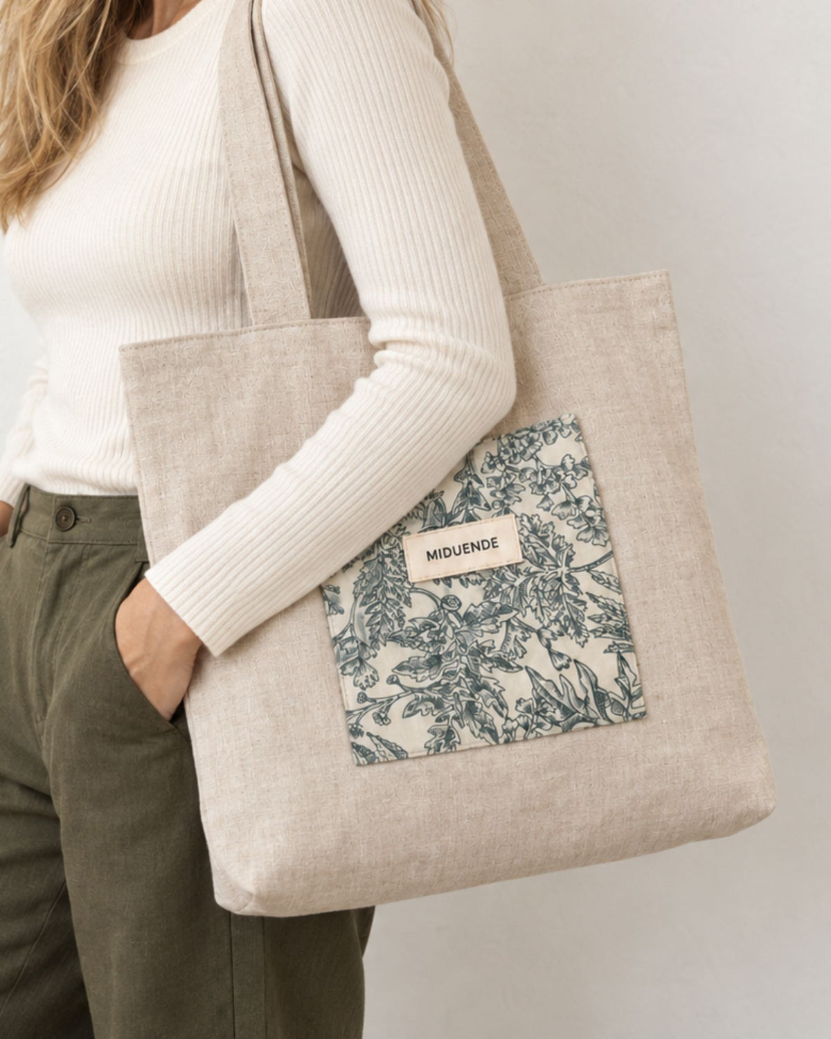 Modelo con bolso totebag de lino con amplio bolsillo exterior acolchado en Jara verde